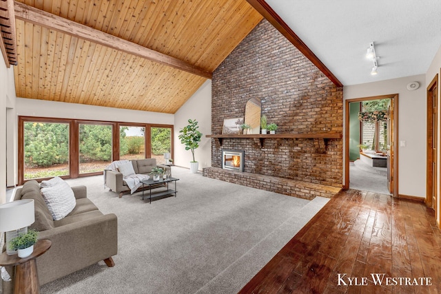carpeted living room with a wealth of natural light, a brick fireplace, high vaulted ceiling, hardwood / wood-style flooring, and beam ceiling