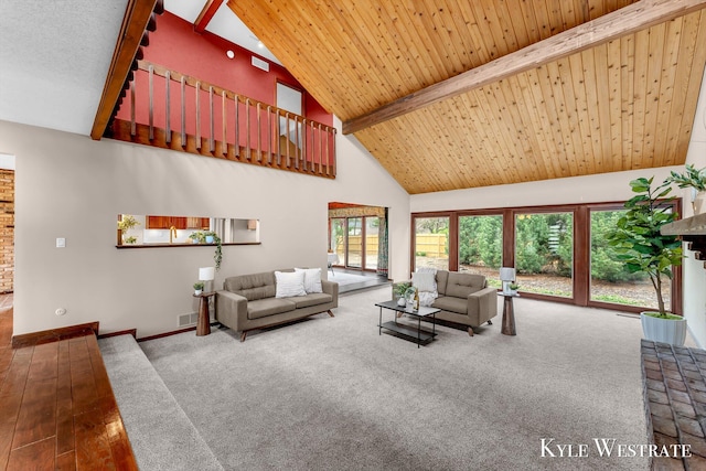 carpeted living area with wood-type flooring, high vaulted ceiling, visible vents, baseboards, and beamed ceiling