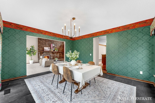 dining room with a fireplace, a notable chandelier, baseboards, and wallpapered walls