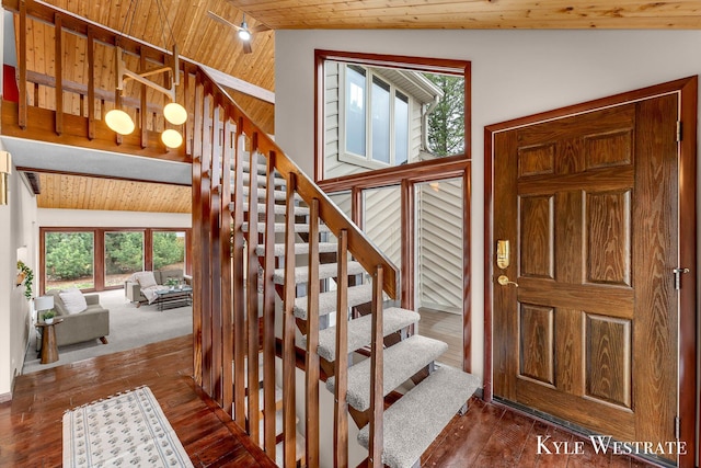 stairway with a wealth of natural light, wooden ceiling, and hardwood / wood-style flooring