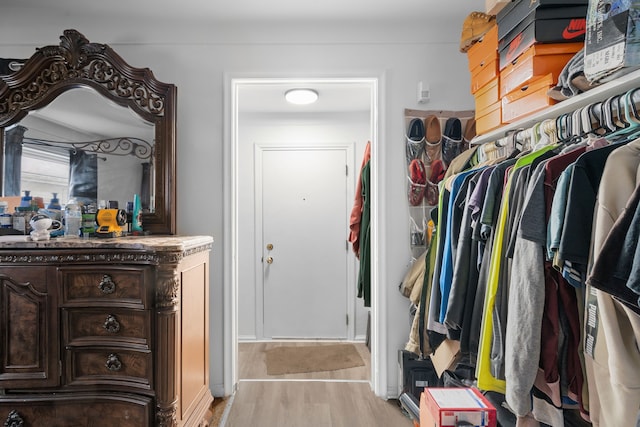 walk in closet with light wood-style flooring