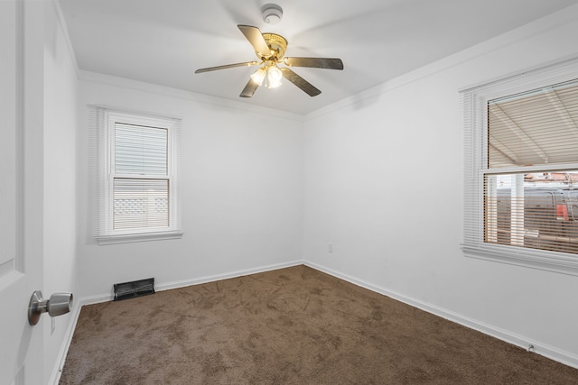 carpeted empty room featuring ceiling fan, crown molding, and baseboards