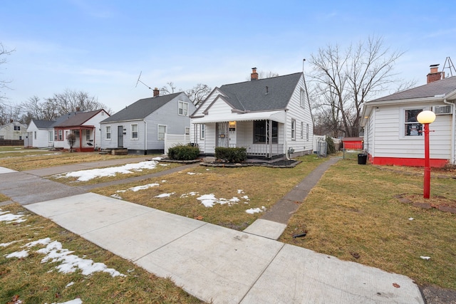 bungalow-style home featuring covered porch, a front yard, and a residential view