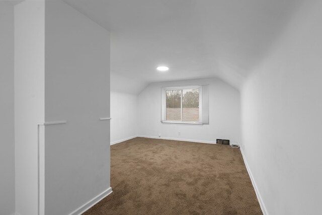 bonus room featuring vaulted ceiling, carpet floors, and baseboards