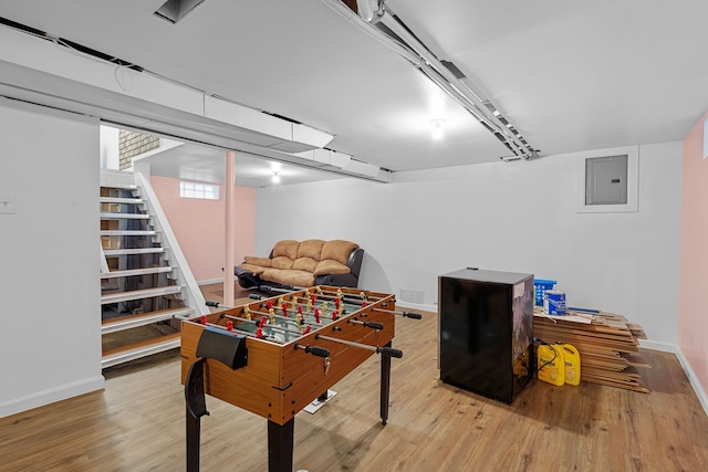 game room with electric panel, baseboards, and wood finished floors