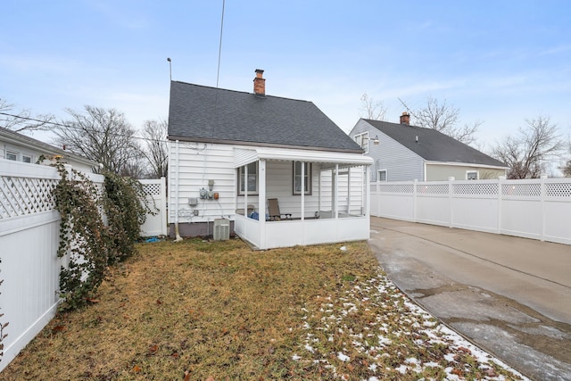 back of house with roof with shingles, a chimney, cooling unit, and a patio area