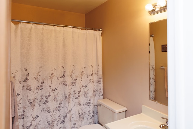 bathroom featuring toilet, vanity, and curtained shower