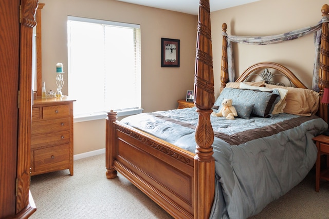 bedroom with baseboards and light carpet