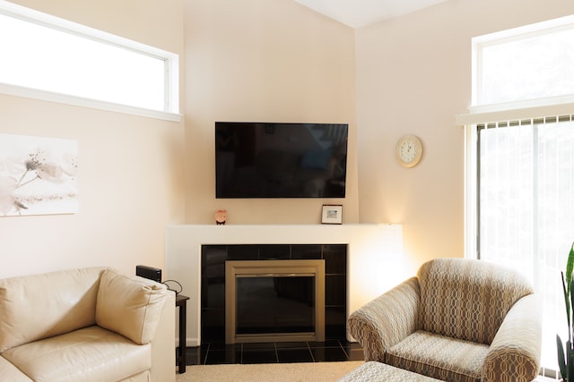 living room with a tile fireplace and tile patterned flooring