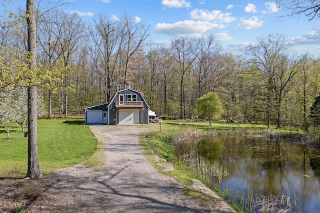 3370 Breezewood, Ortonville, MI 48462 - garage featuring a garage, asphalt driveway, a forest view, and a water view