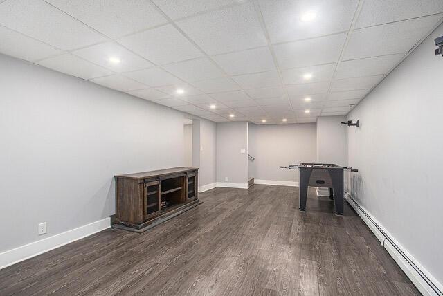2737 Patricia Dr, Muskegon, MI 49445 - finished below grade area featuring wood finished floors, a baseboard heating unit, recessed lighting, and a drop ceiling