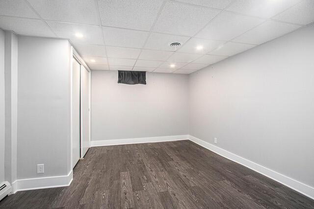 2737 Patricia Dr, Muskegon, MI 49445 - finished below grade area featuring wood finished floors, a paneled ceiling, a baseboard heating unit, and recessed lighting