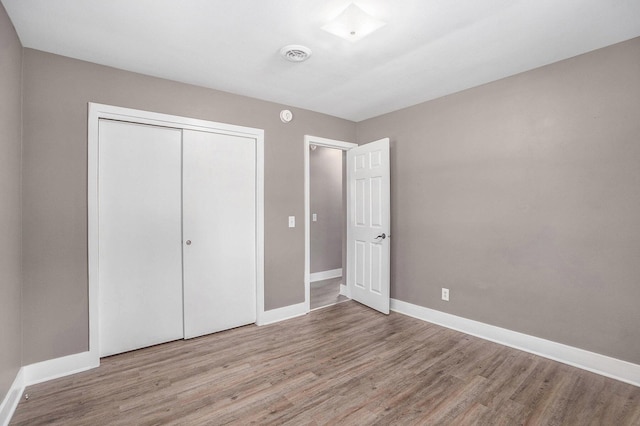 2737 Patricia Dr, Muskegon, MI 49445 - unfurnished bedroom featuring wood finished floors and a closet