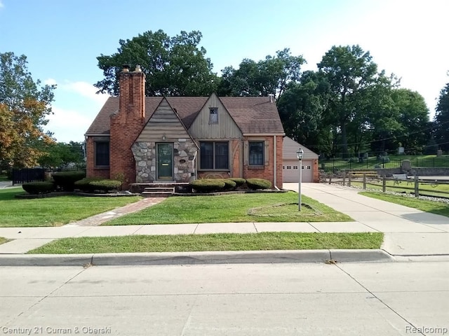 23211 Myrtle St, Dearborn, MI 48128 - tudor house with fence, a front lawn, a chimney, and driveway
