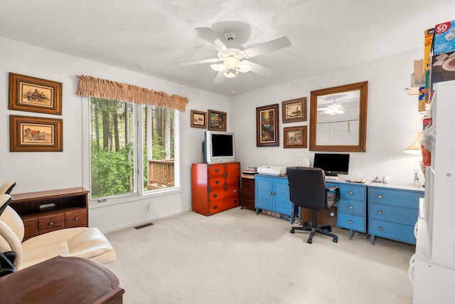 home office featuring a ceiling fan, baseboards, visible vents, and light colored carpet