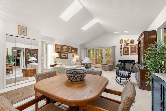 dining room with a skylight, a textured ceiling, and high vaulted ceiling