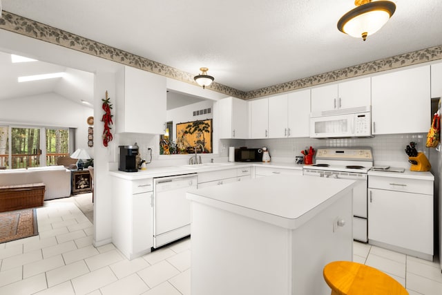 kitchen with a sink, white appliances, visible vents, backsplash, and light countertops