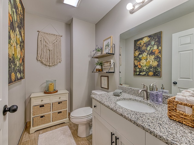 half bath featuring toilet and vanity