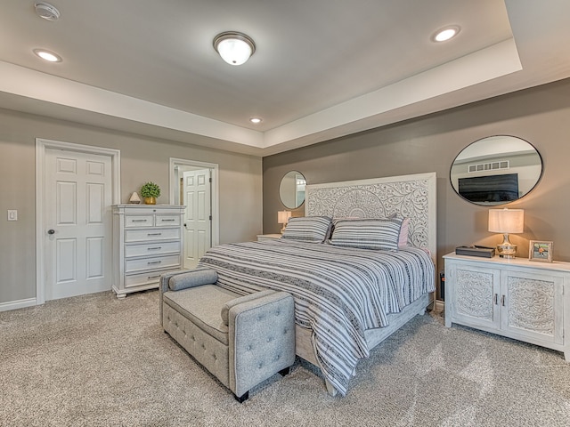bedroom featuring a tray ceiling, light carpet, visible vents, and recessed lighting