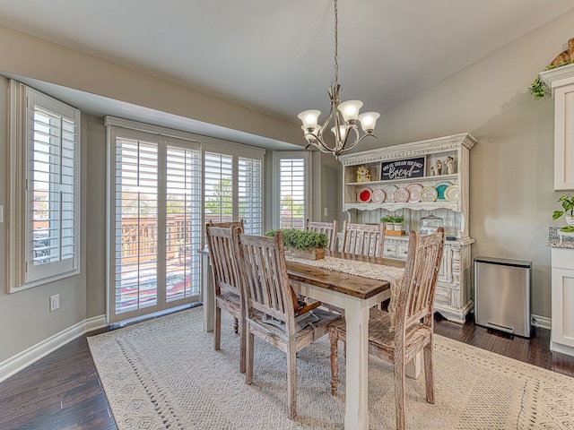 dining space with a chandelier, a healthy amount of sunlight, and dark wood-type flooring
