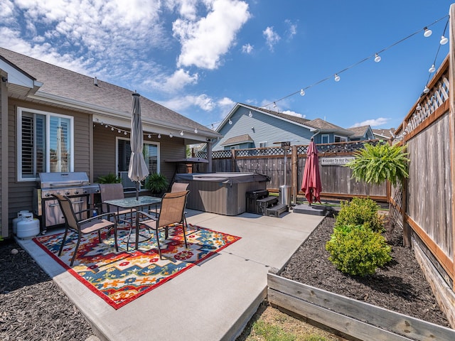 view of patio / terrace with area for grilling, a hot tub, and a fenced backyard