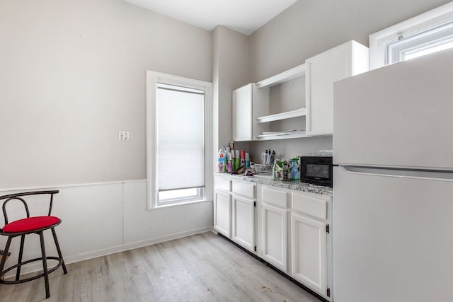 124 S Ottawa St, Tecumseh, MI 49286 - kitchen with freestanding refrigerator, black microwave, a healthy amount of sunlight, and open shelves
