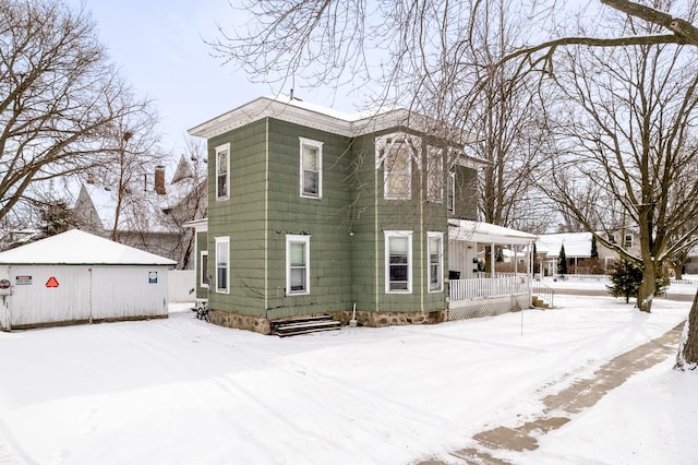 124 S Ottawa St, Tecumseh, MI 49286 - snow covered property featuring an outbuilding and covered porch