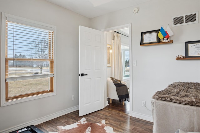 interior space with baseboards, dark wood-style floors, and visible vents