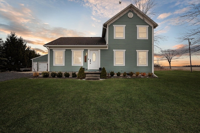 traditional home featuring a yard, a shingled roof, and a garage
