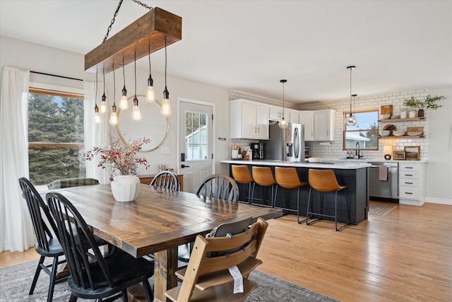 dining space with light wood-style flooring and plenty of natural light