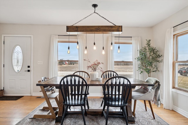 dining space with baseboards and wood finished floors