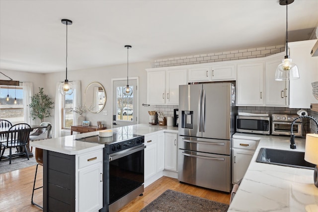 kitchen featuring stainless steel appliances, a peninsula, decorative backsplash, and white cabinets