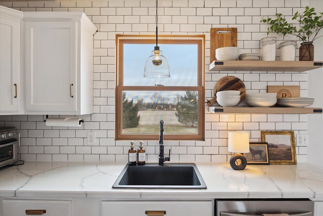 kitchen featuring a sink, open shelves, tasteful backsplash, and white cabinets