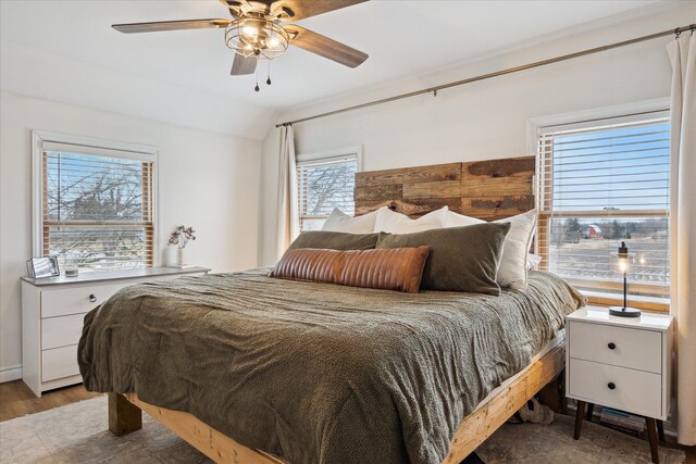 bedroom with a ceiling fan, wood finished floors, and lofted ceiling