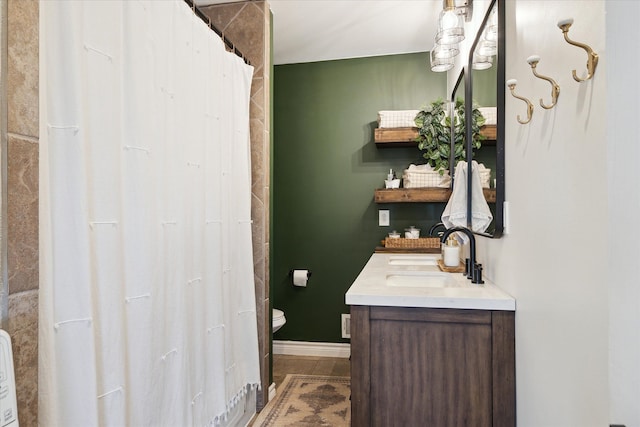 full bath with baseboards and vanity