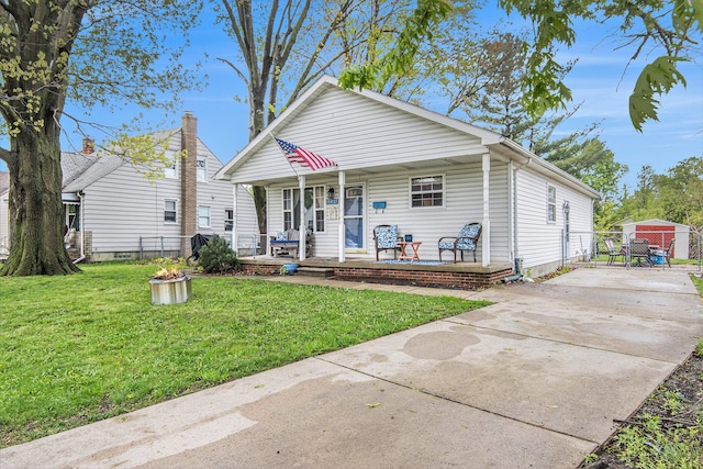 bungalow-style home with driveway, fence, a front yard, a porch, and a gate