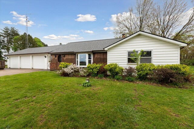 single story home with concrete driveway, a front yard, roof with shingles, and an attached garage