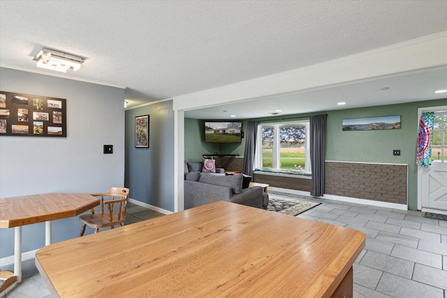 dining room with a wealth of natural light, crown molding, and a textured ceiling