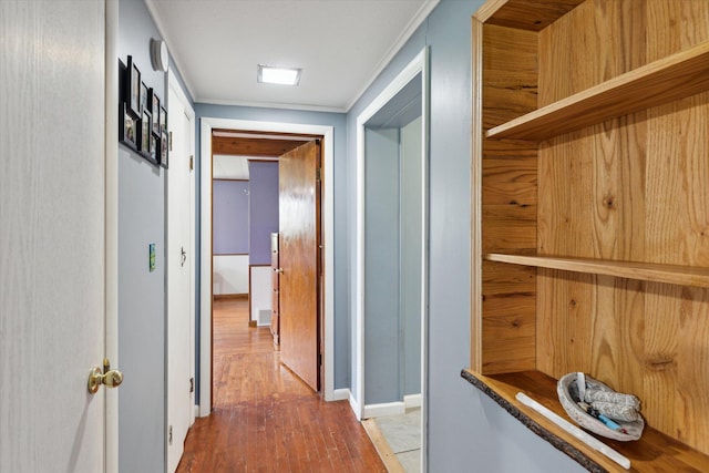 hallway featuring wood finished floors and ornamental molding