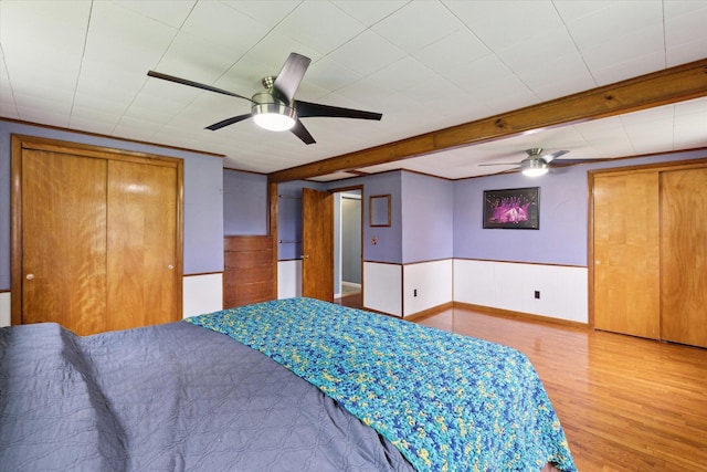 bedroom with beamed ceiling and wood finished floors