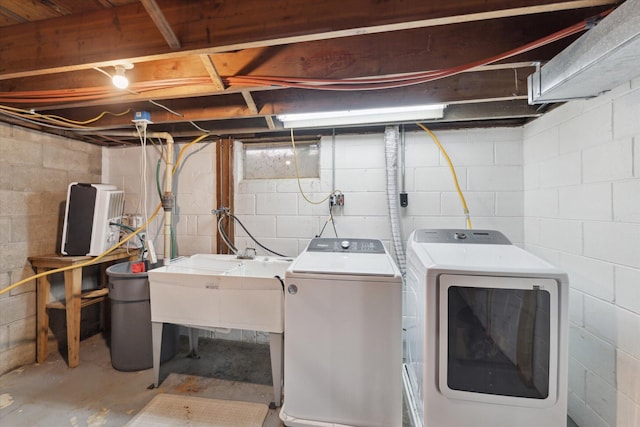 clothes washing area with washer and dryer, laundry area, and a sink