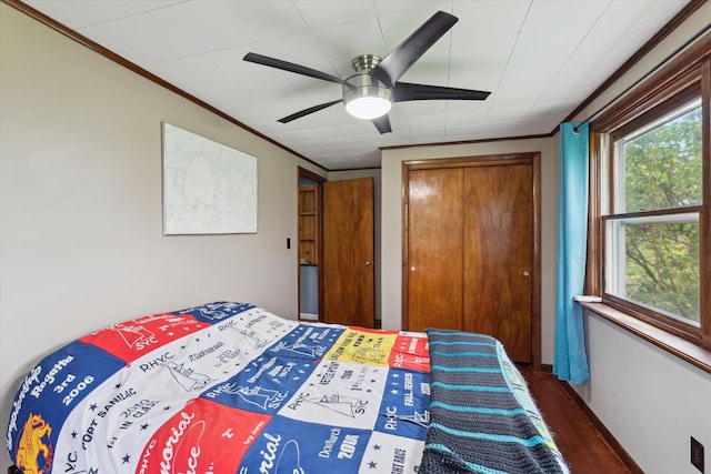 bedroom with crown molding, a closet, wood finished floors, and ceiling fan
