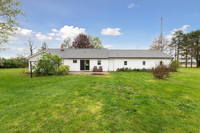 back of house featuring a yard, a patio area, and a chimney