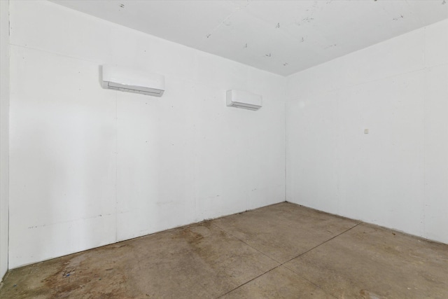 unfurnished room featuring concrete floors and a wall unit AC