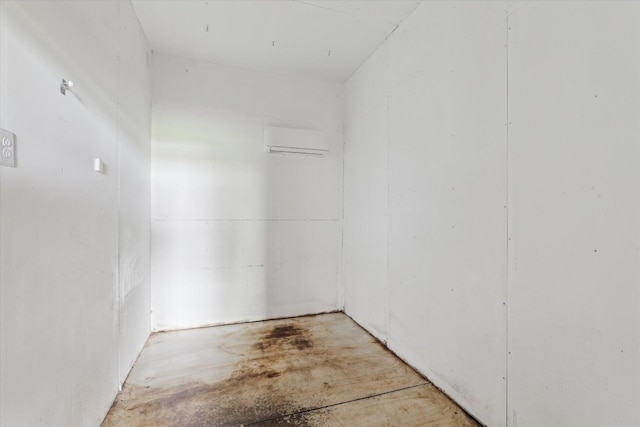 interior space with a wall mounted air conditioner and concrete flooring