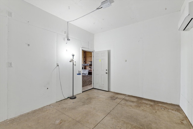 unfurnished room featuring concrete flooring and a wall mounted AC