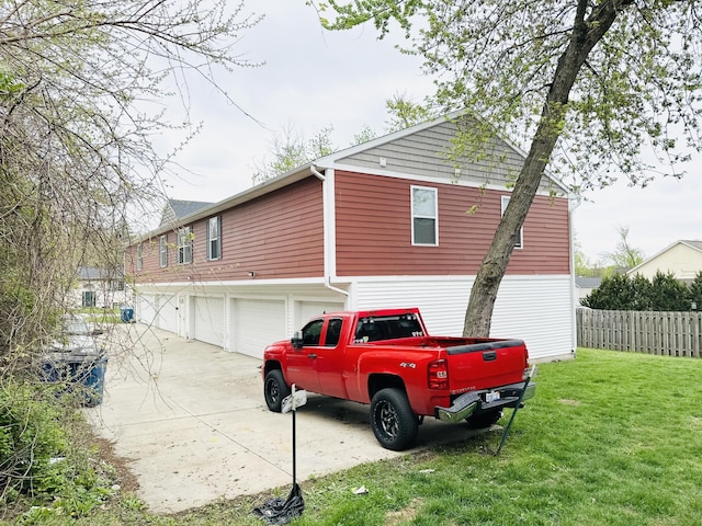 1312 Lafayette Ave, Kalamazoo, MI 49006 - view of side of property featuring concrete driveway, an attached garage, fence, and a lawn