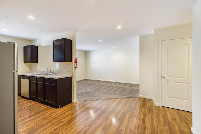 1312 Lafayette Ave, Kalamazoo, MI 49006 - kitchen featuring light wood-style flooring, stainless steel appliances, dark brown cabinets, a sink, and light countertops