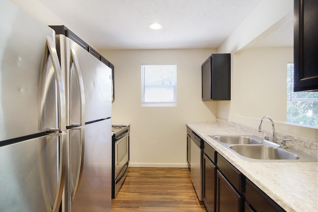 1312 Lafayette Ave, Kalamazoo, MI 49006 - kitchen with baseboards, dark wood-style flooring, a sink, light countertops, and appliances with stainless steel finishes