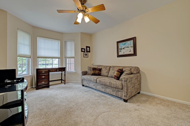 living area with ceiling fan, carpet floors, and baseboards